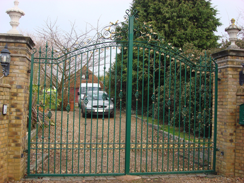 Green wrought iron driveway gates with door entry system. We made these gates in our Park Royal factory.