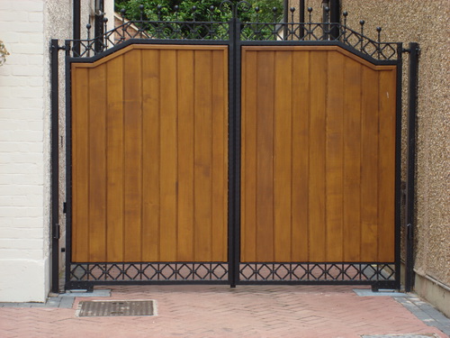 A pair of wooden side gates in wrought iron frame for extra security.